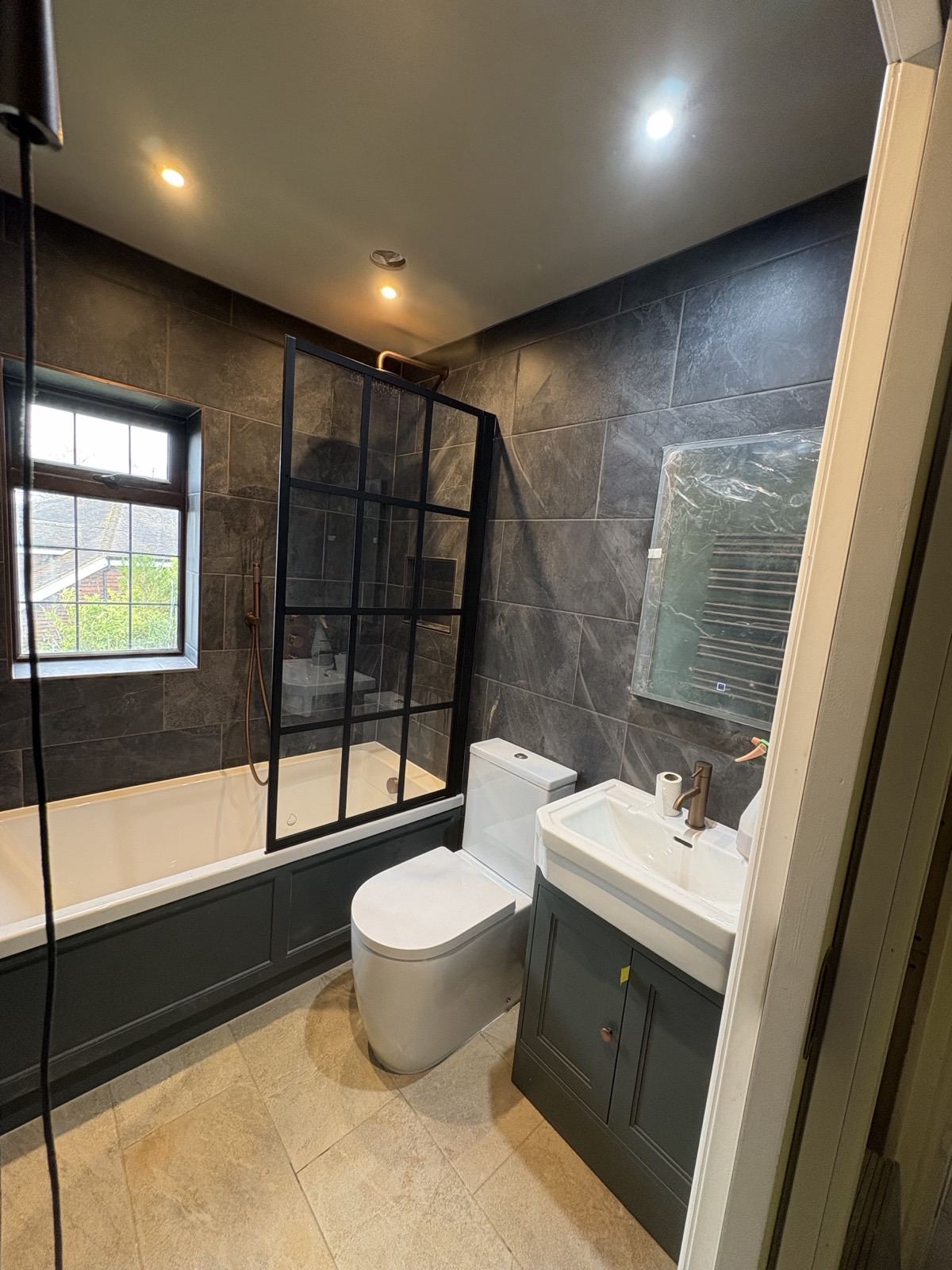 Bathroom with a black-framed shower screen after renovation