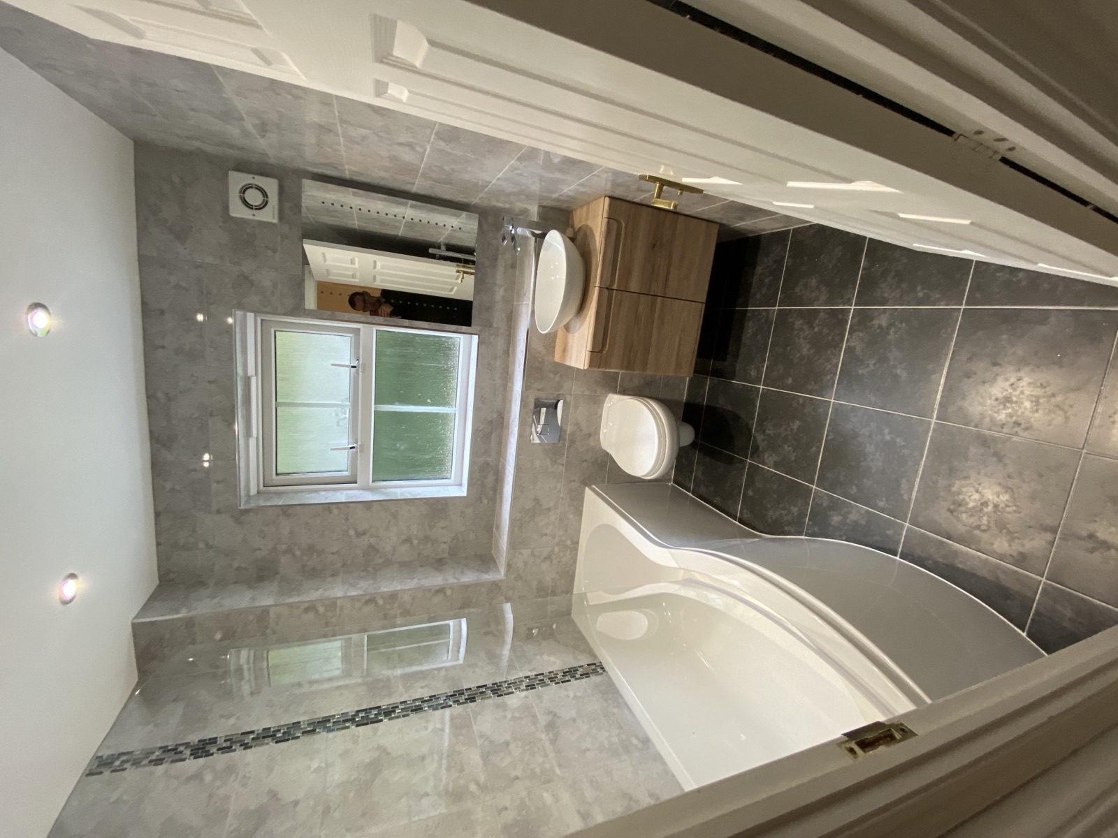 Premium bathroom renovation with stone-effect tiling and freestanding bath